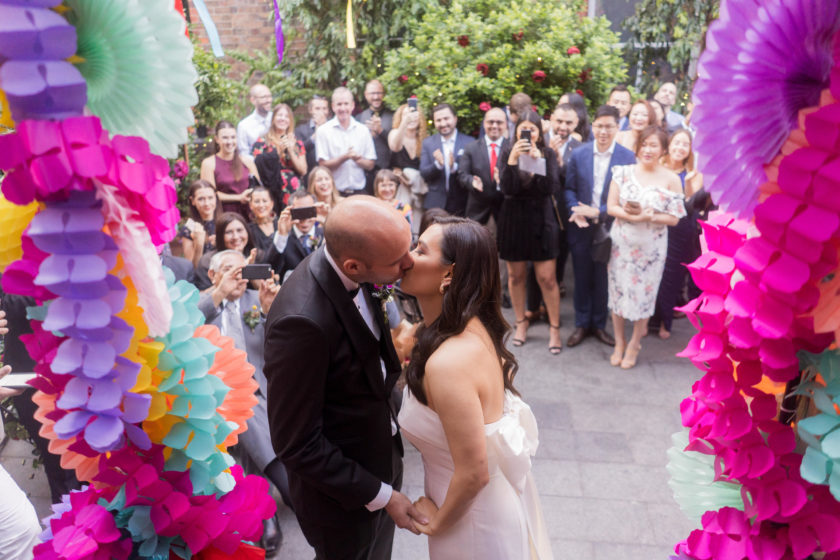 Wedding kiss GoldHatPhotography Married couple kissing under wedding arch